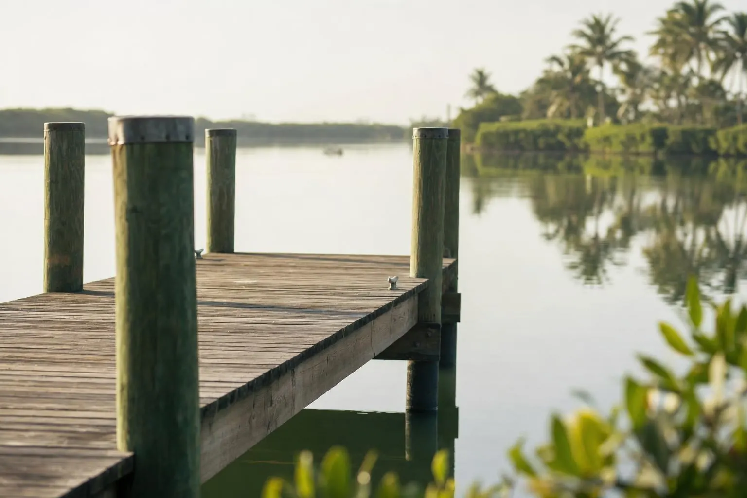 A calm dock over still water at dawn